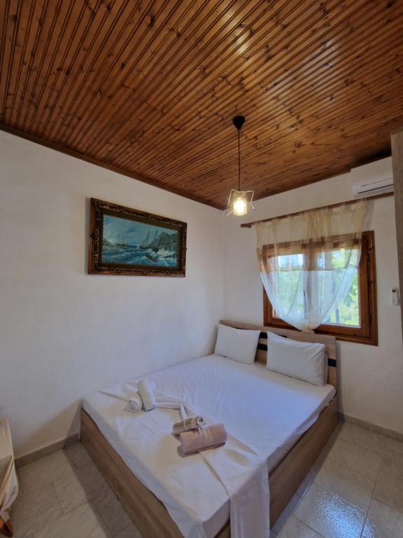 a bed in a room with a wooden ceiling at Dream in Chalkidiki 2 bedroom villa with garden in Néa Tríglia