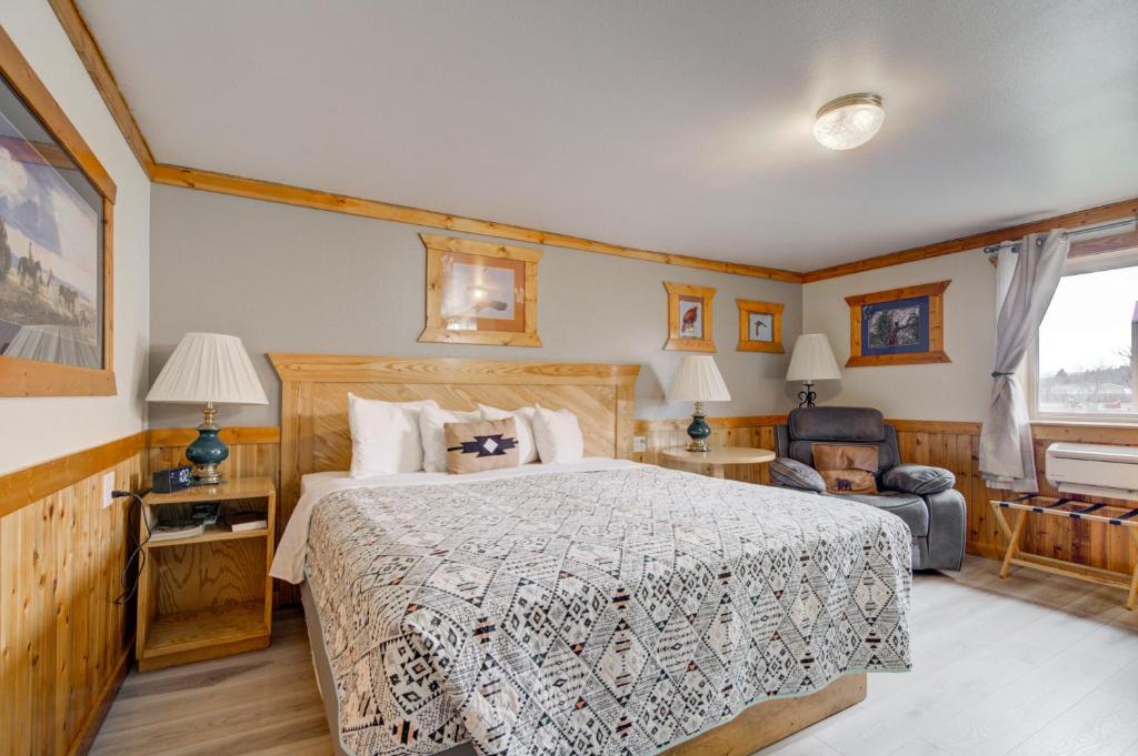 a bedroom with a large bed and a chair at Livingston Inn - Historic in Livingston