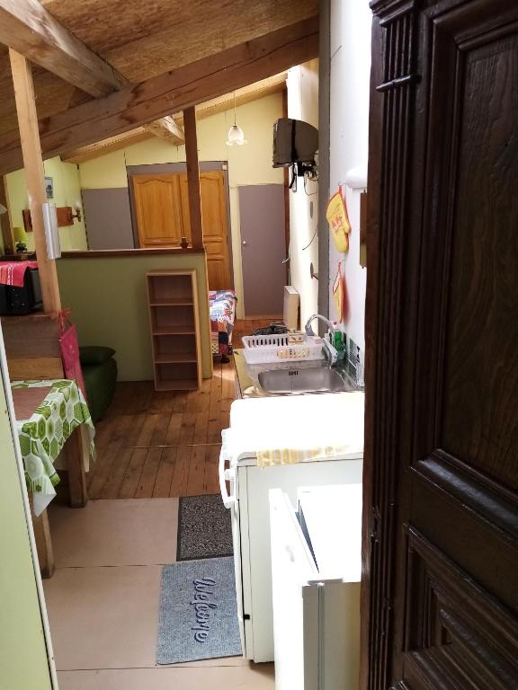 een kamer met een keuken met een tafel en een fornuis bij La cabane in Palogneux