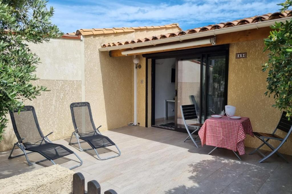 a patio with a table and chairs on a deck at Cap d'Agde Naturiste Villa Port Vénus in Cap d'Agde