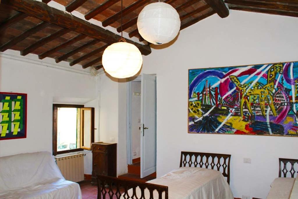 パンツァーノにあるTorrione Apartmentのベッド2台が備わる客室で、壁には絵画が飾られています。
