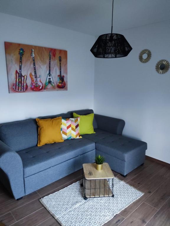 eine blaue Couch in einem Wohnzimmer mit Gitarren an der Wand in der Unterkunft Apartment Ivante in Kaštela