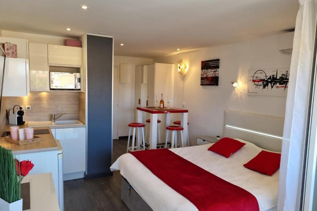 une petite chambre avec un lit et une cuisine dans l'établissement Naturiste Cap d'Agde Port Vénus 104, au Cap d'Agde