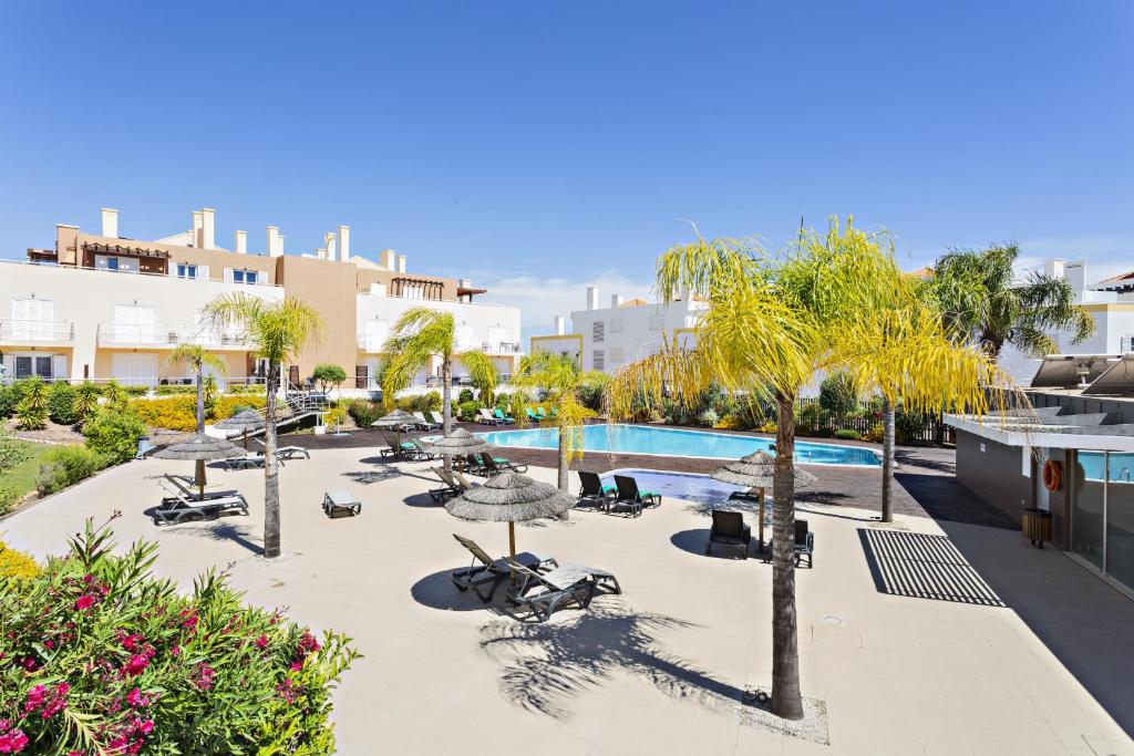 a resort with a swimming pool and palm trees at Cabanas Gardens by MY CHOICE in Cabanas de Tavira