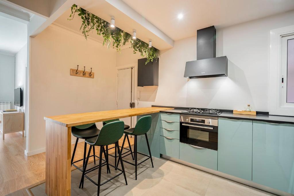 a kitchen with blue cabinets and a counter with stools at Barcelona Eixample in Barcelona