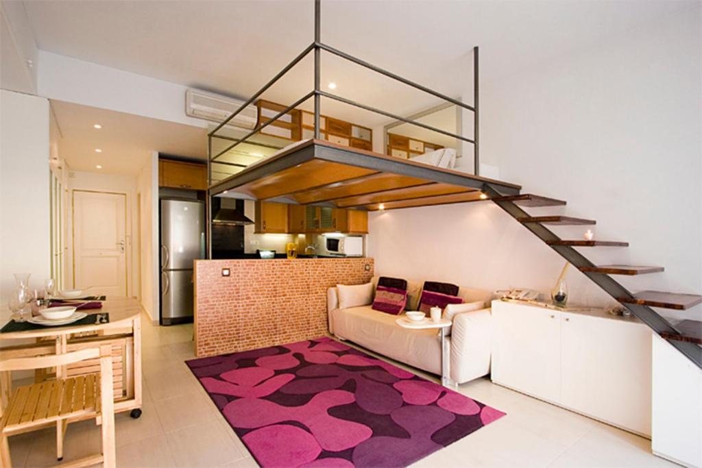 a living room with a couch and a staircase at Reina Amalia Apartment in Barcelona