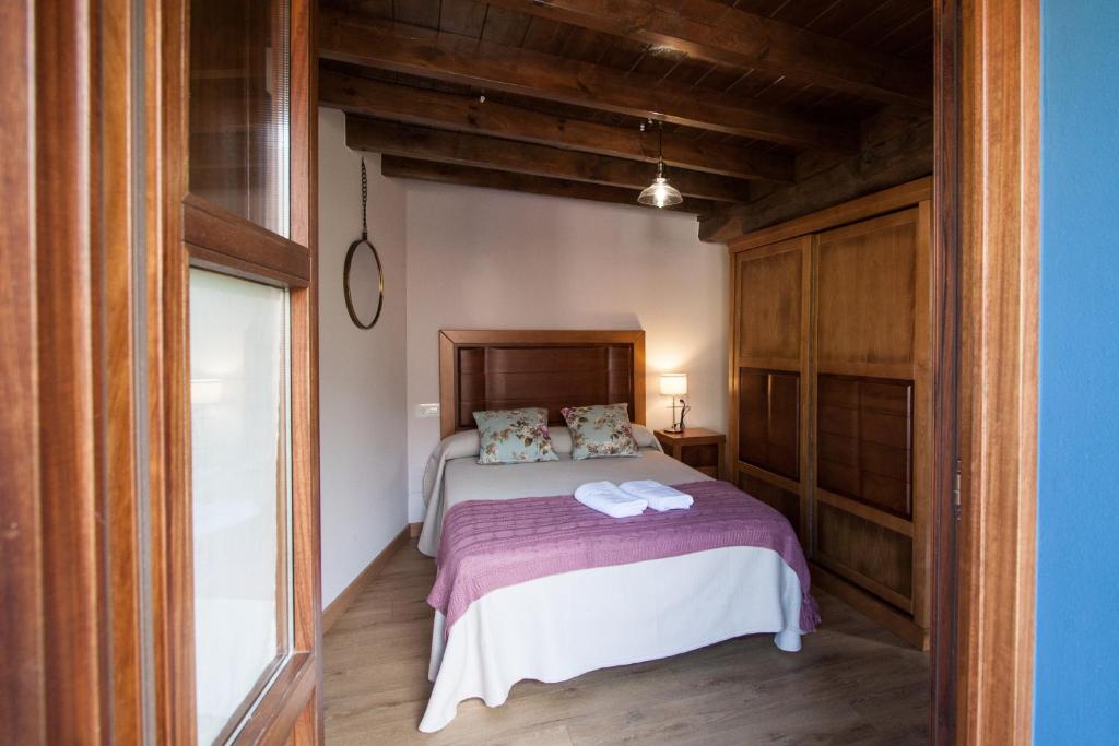 1 dormitorio con 1 cama con 2 toallas en Madre Rosa I, casa rural con la playa a 12 km, en Llanes