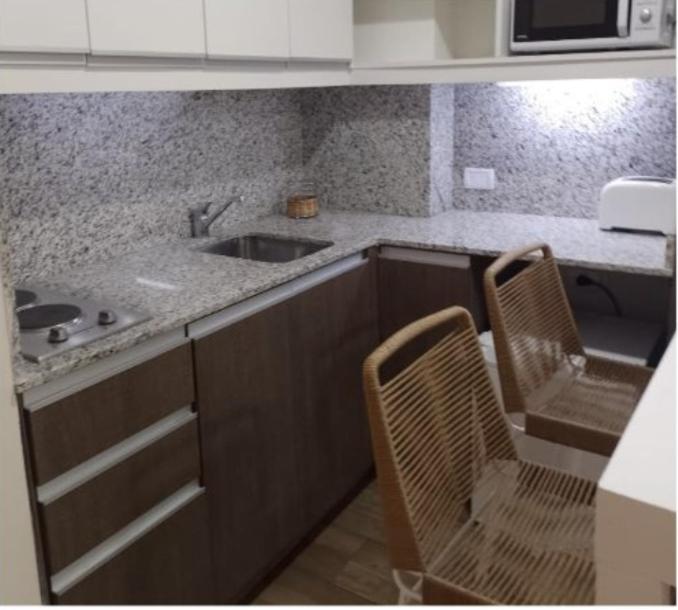 una cocina con fregadero y 2 sillas. en 2 ambientes moderno y muy bien ubicado en Buenos Aires