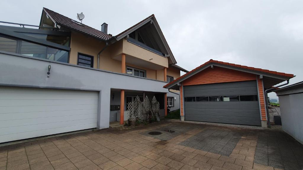 a house with two garage doors and a driveway at Alpenblick in Leutkirch im Allgäu