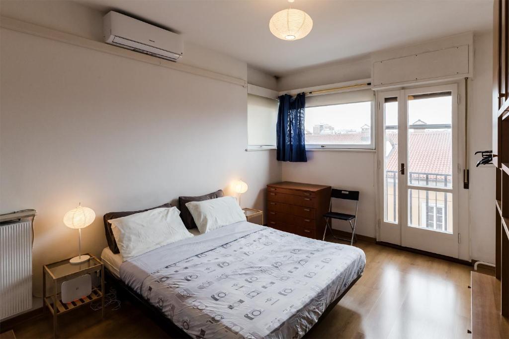 una camera con un letto e una grande finestra di Appartamento Slataper - ampio e con vista a Trieste