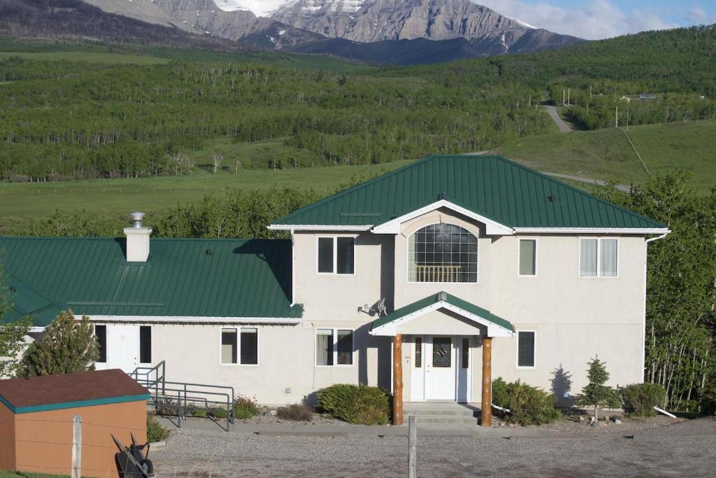 a large white house with a green roof at Waterton Country Villas in Waterton Park