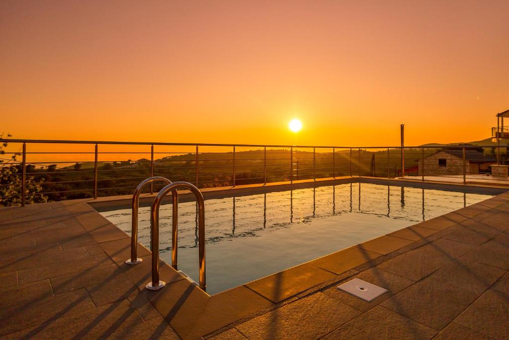 una piscina con una puesta de sol en el fondo en The View Villa, en Maryiés