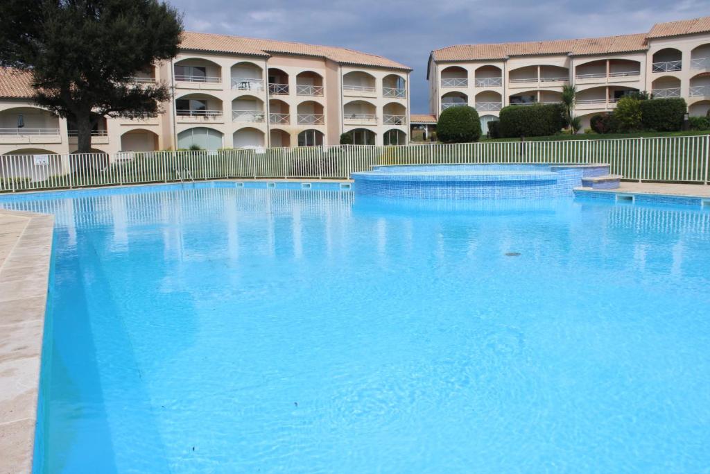 a large blue swimming pool in front of a building at Moliets plage, Résidence OPEN SUD in Moliets-et-Maa