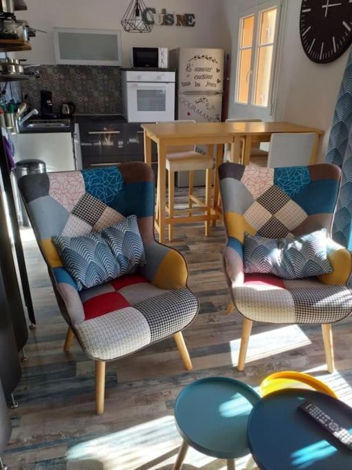 un salon avec deux chaises et une table dans l'établissement Charmant studio climatisé proche de la mer, à Sanary-sur-Mer