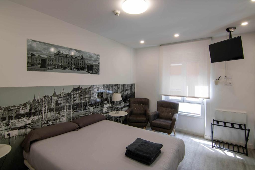 レオンにあるSuite estocolmoのベッドルーム(ベッド1台、ソファ、椅子付)