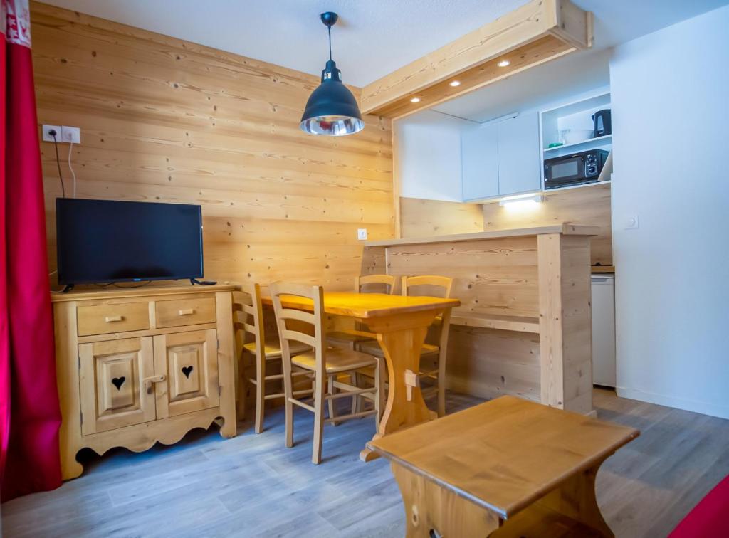 a kitchen with a table and a television in a room at Appartement cosy 1 chambre 4 pers face pistes 09 in LʼHuez