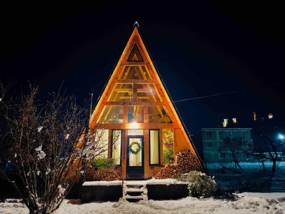 a small house with a triangular roof in the snow at A-frame mestia in Mestia
