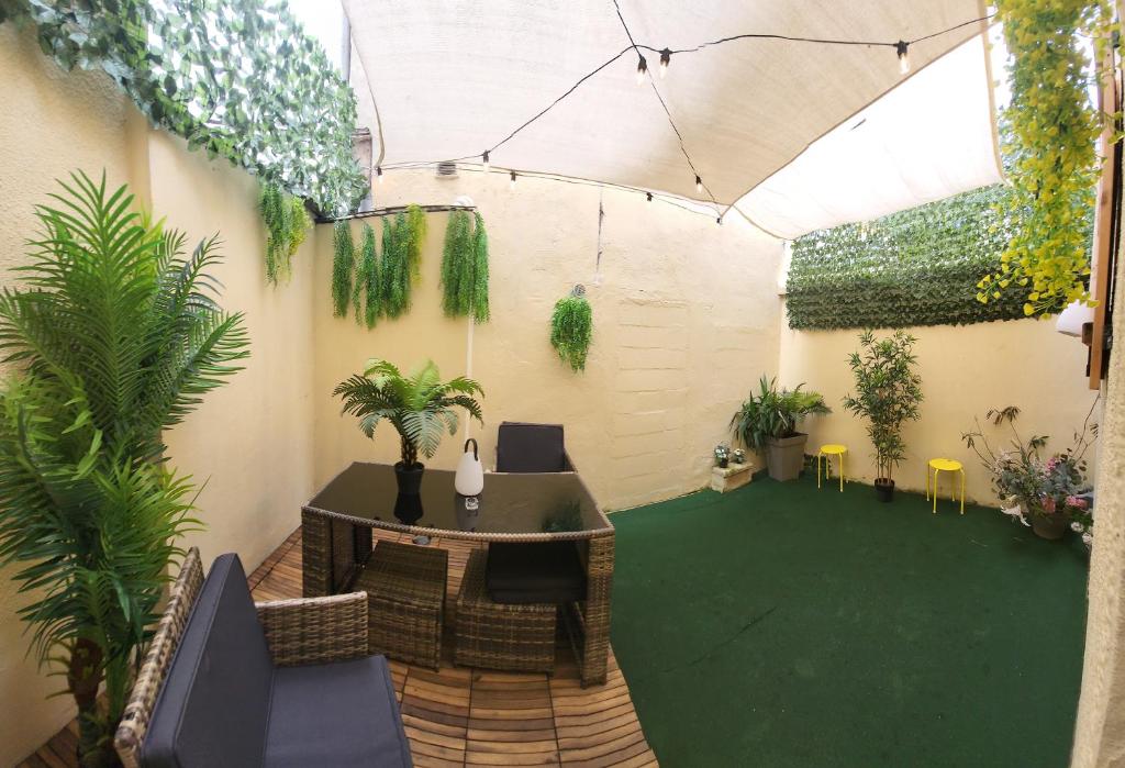 a patio with a table and chairs and plants at Paris Malakoff Garden Apartments in Malakoff