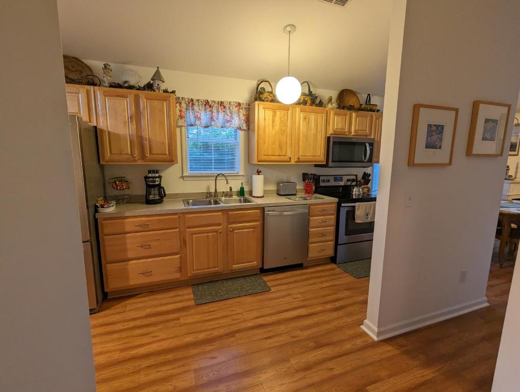 a kitchen with wooden cabinets and stainless steel appliances at Great Central Location - Between Everything in Myrtle Beach