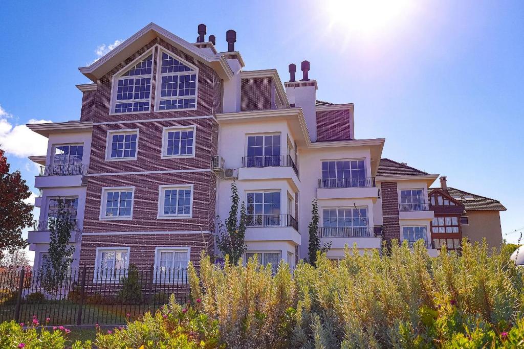 una grande casa con il sole dietro di essa di Residencial London AP 104 a Gramado