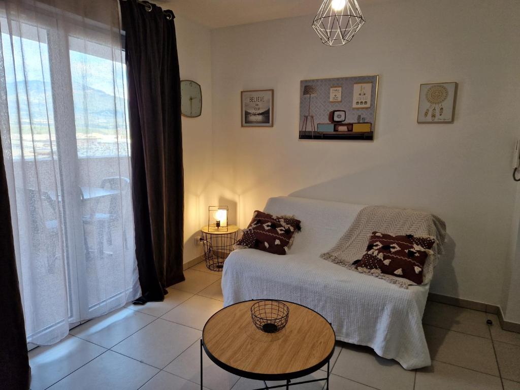 1 dormitorio con cama, mesa y ventana en Studio cosy proche toutes commodités avec parking gratuit, en Mezzavia