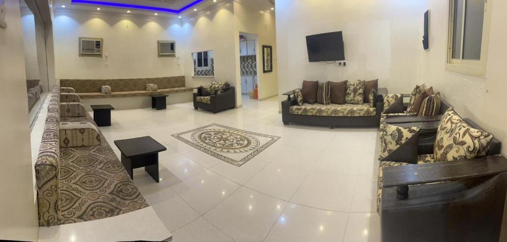 un ampio soggiorno con divani e TV di استراحة بغرفة نوم ومسبح ألعاب مائيه a Ḩarāḑah