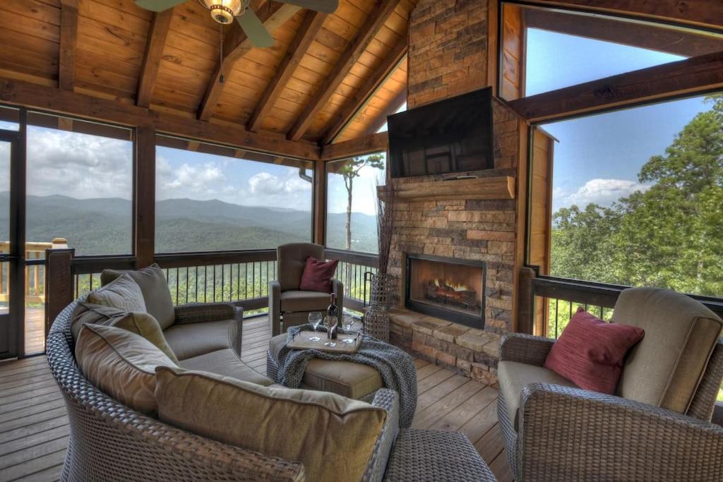 a screened in porch with couches and a fireplace at Sunset Ridge w Stunning 5 Star Views & Hot Tub in Blue Ridge