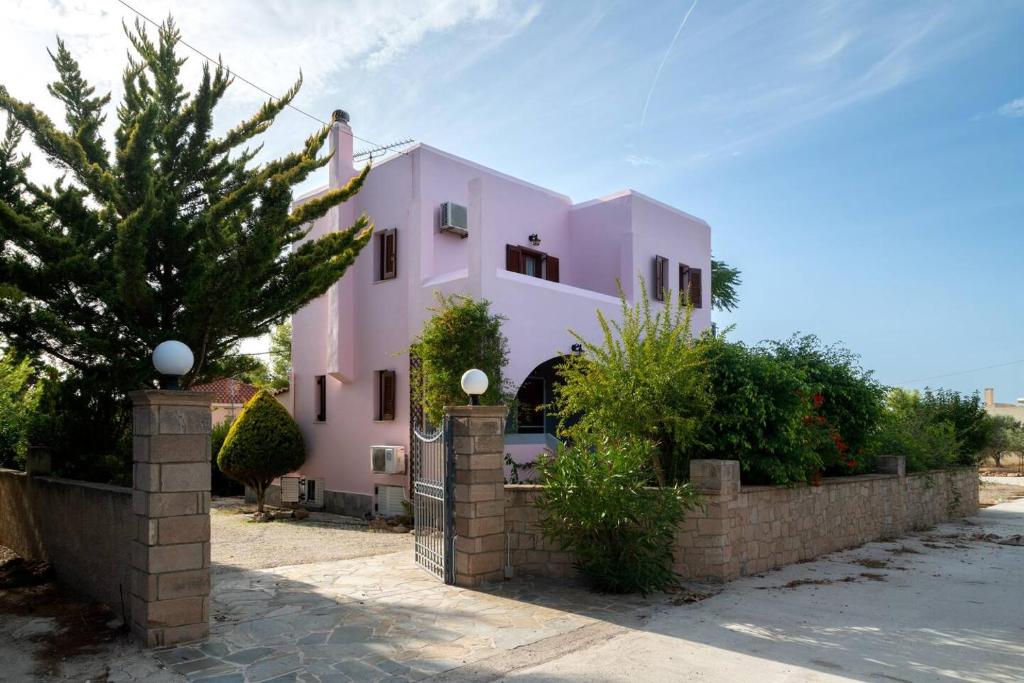 uma casa cor-de-rosa com uma vedação à frente. em Norma’s House em Khlóï