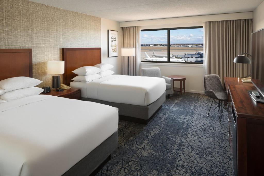 a hotel room with two beds and a desk at Sheraton Hartford Hotel at Bradley Airport in Windsor Locks