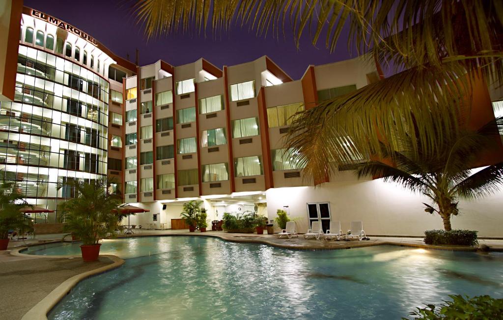 un hotel con piscina frente a un edificio en Hotel El Marqués, en Atacames