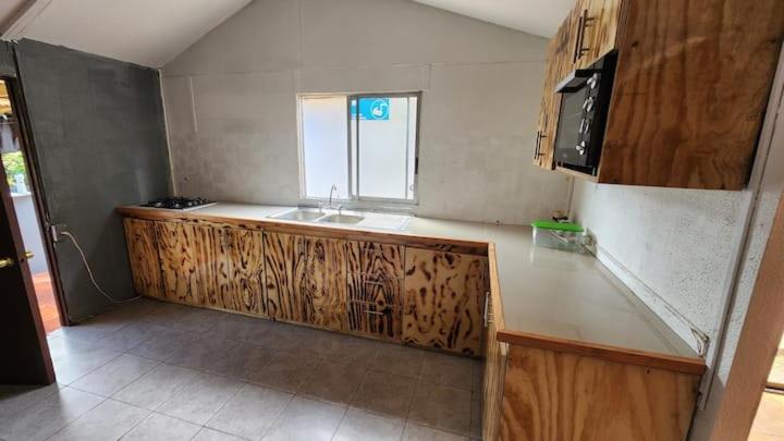 uma cozinha com um balcão e um lavatório em marari rapa nui em Hanga Roa