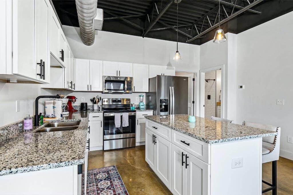 a kitchen with white cabinets and granite counter tops at Brand New Condo near downtown Nash w washer dryer in Nashville