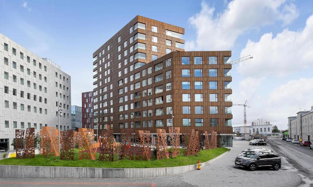 un grand bâtiment brun avec une pelouse verte devant lui dans l'établissement Loft-Style Duplex with Balcony in Downtown Reykjavík, à Reykjavik