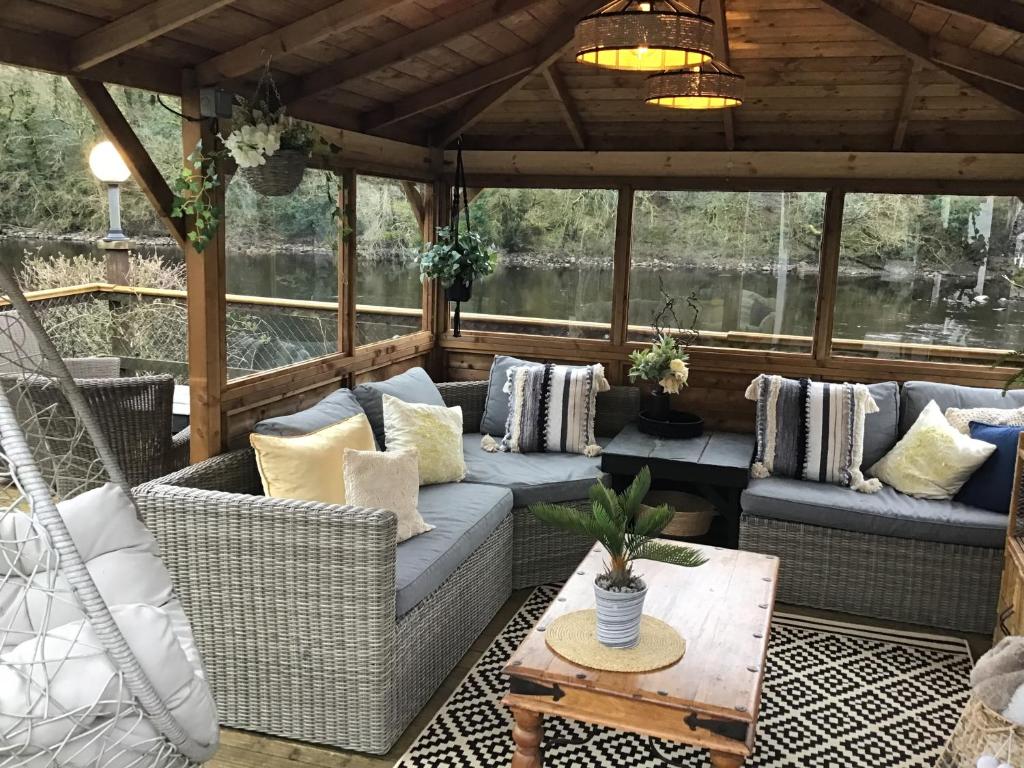 a screened in porch with couches and a table at The Haven B&B in Castle Douglas