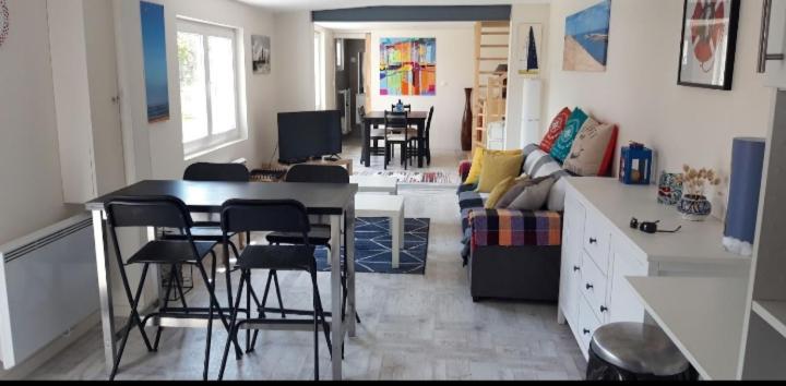 uma cozinha e sala de estar com mesa e cadeiras em Maison proche océan em Saint-Hilaire-de-Riez