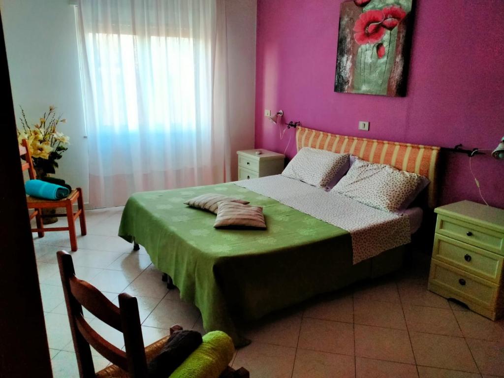 1 dormitorio con 1 cama con manta verde en Agriturismo la Cantina, en Baratili San Pietro
