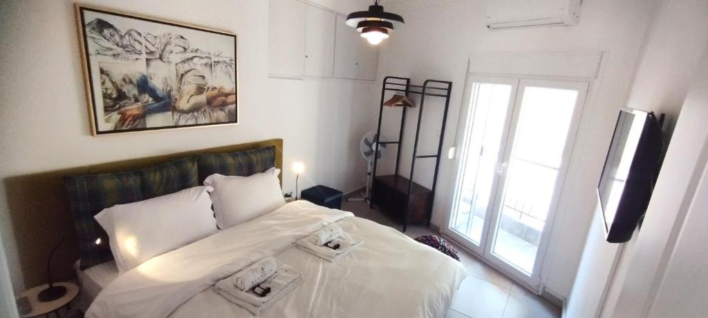 um quarto com uma cama com lençóis brancos e uma janela em Zennova #9 City Center Pearl em Tessalônica