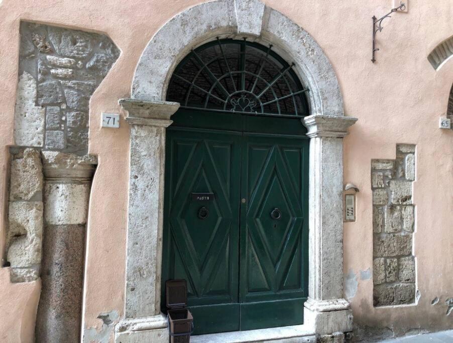 une porte verte sur le côté du bâtiment dans l'établissement Appartamento nel Borgo, à Orte