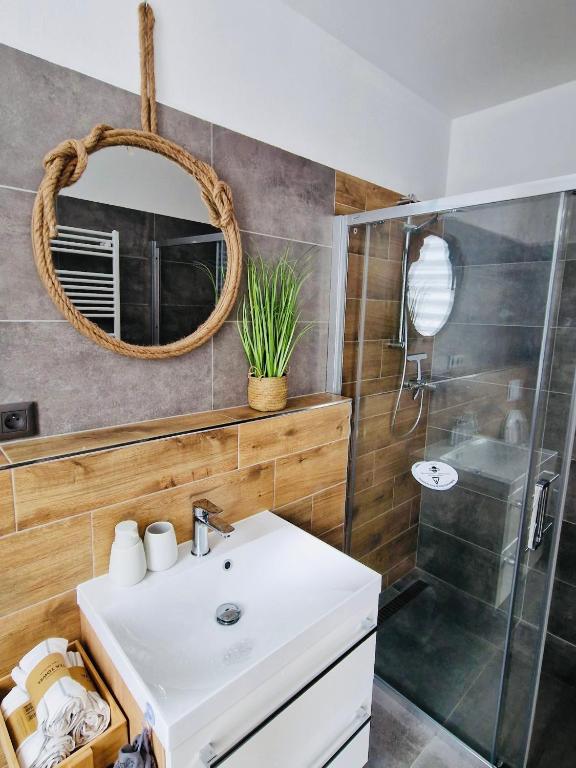 a bathroom with a sink and a shower and a mirror at Apartmán Jestřábí Lipno in Černá v Pošumaví