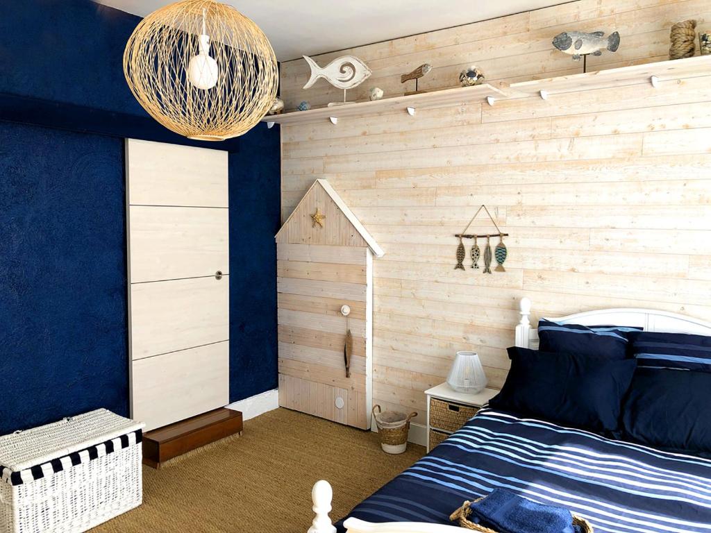1 dormitorio con una pared de madera azul en LA SOURCE DE BARDON, en Saint-Aignan