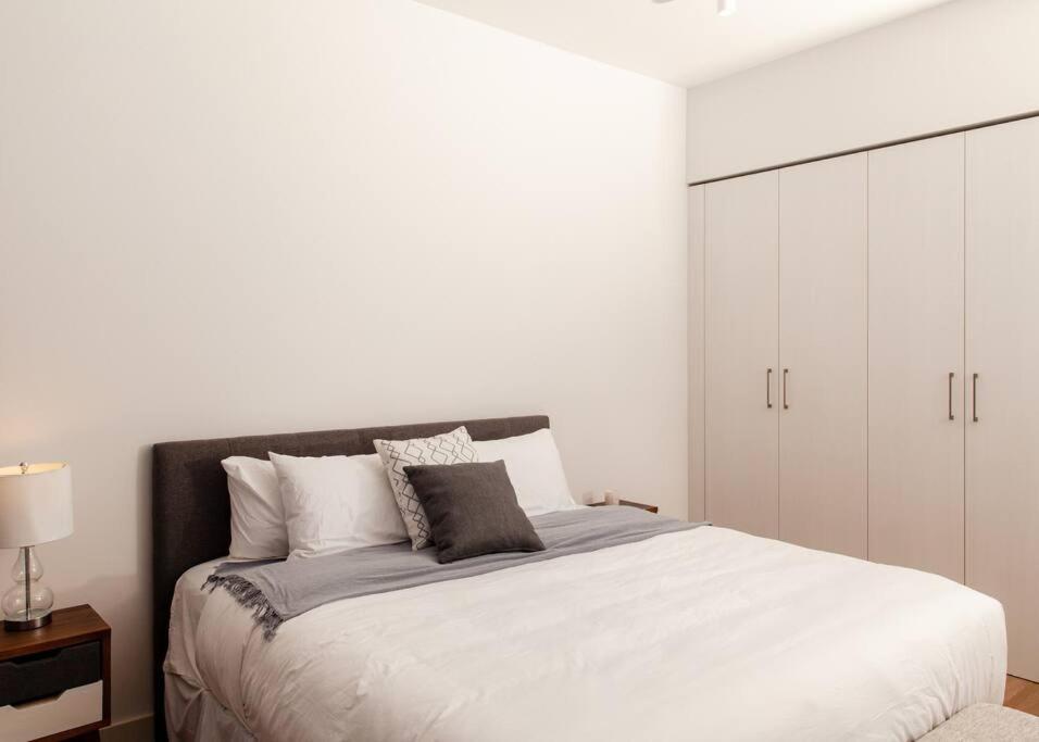 um quarto com uma cama grande e armários brancos em Apartamento una habitación DLX em Echeverría