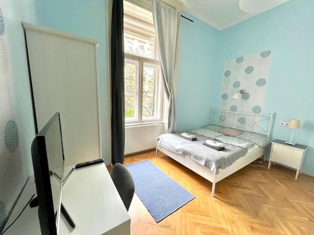 ein kleines Schlafzimmer mit einem Bett und einem Fenster in der Unterkunft Jazzy Vibes Parliament Rooms and Ensuites in Budapest