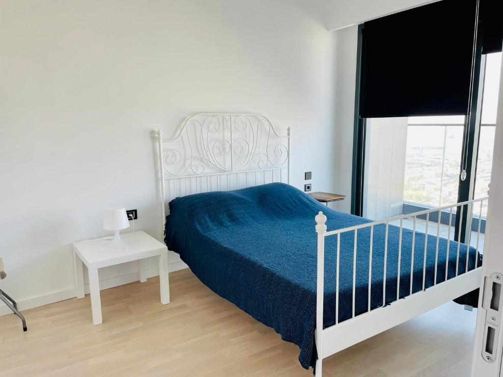 a bedroom with a white bed with a blue blanket at Luxury residence with sea view in Konak