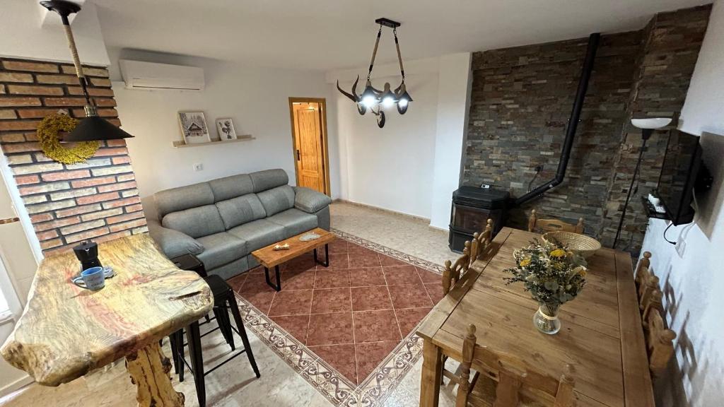 un soggiorno con divano e tavolo di El Rincón de Alejandro ad Arroyo Frio