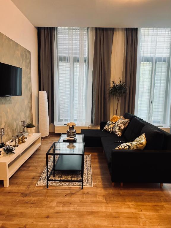 een woonkamer met een zwarte bank en een tafel bij SOFI living in Ostrava