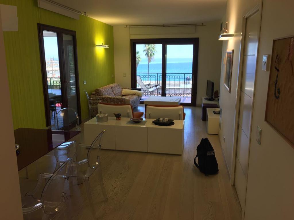 DHOME Baia Mazzaro' في تاورمينا: غرفة معيشة مع أريكة وطاولة