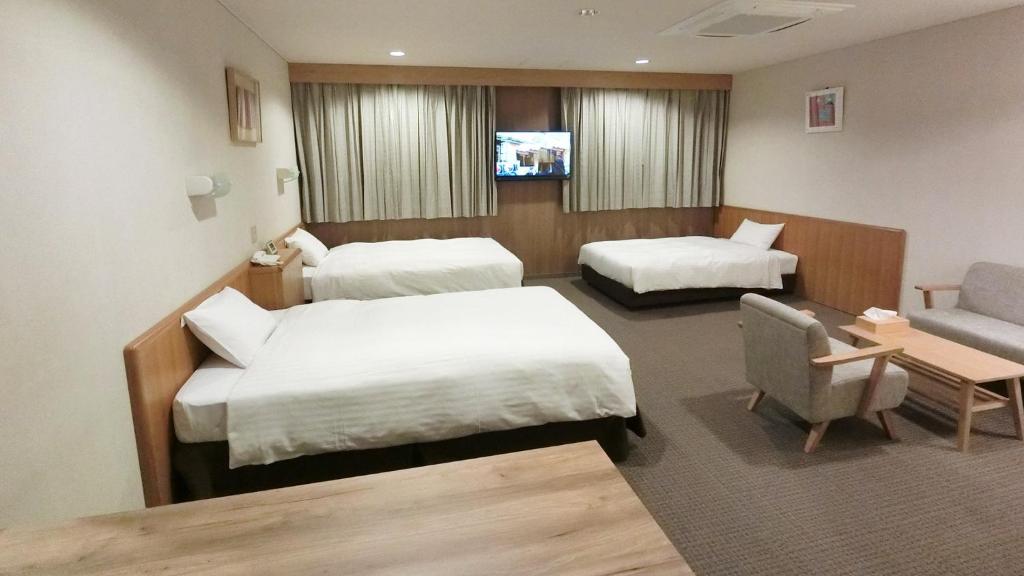 由利本荘市にあるYurihonjo - Hotel - Vacation STAY 42526vのベッド2台とソファが備わるホテルルームです。