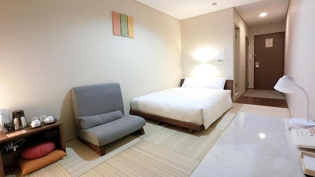 um quarto de hotel com uma cama e uma cadeira em Yurihonjo - Hotel - Vacation STAY 42534v em Yurihonjo