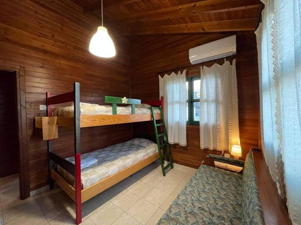 a bedroom with two bunk beds in a cabin at Koilani Village House in Koilani