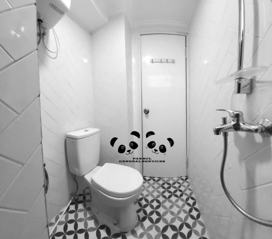 a bathroom with a toilet and a black and white at Apartment Kalibata City by PanBul in Jakarta